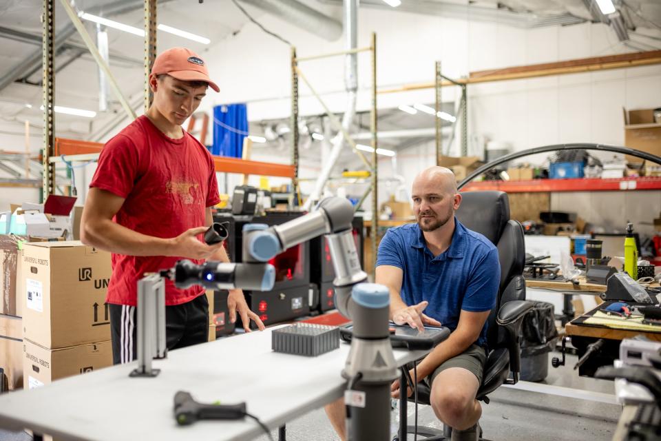 Wesley Murray and Jason Marshall work with a robotic arm used for assembling products at Merit3D in Price on Thursday, Aug. 17, 2023. | Spenser Heaps, Deseret News