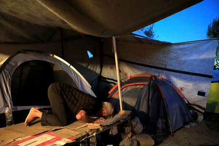 A migrant prays inside his tent at a makeshift camp next to the Moria camp for refugees and migrants on the island of Lesbos, Greece, September 17, 2018. Picture taken September 17, 2018. REUTERS/Giorgos Moutafis