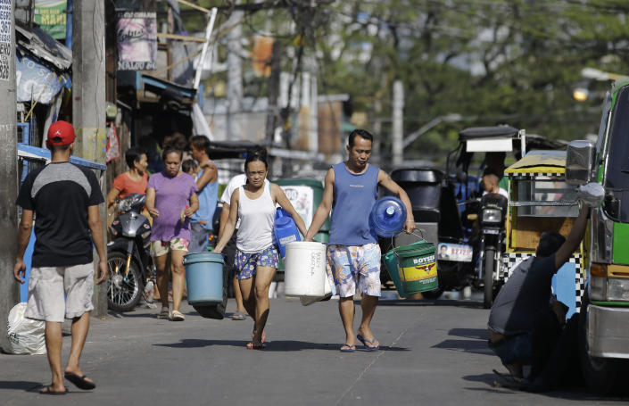 A couple carries empty containers looking for places to collect water in Mandaluyong, metropolitan Manila, Philippines on Thursday, March 14, 2019. Aside from the daily line of residents waiting for water rations from trucks, many businesses like laundry shops, carwash and water-purifying stations in Manila have been affected by a water shortage from the Manila Water Company due to low levels at the La Mesa dam and the onset of El Nino which causes below normal rainfall conditions. (AP Photo/Aaron Favila)