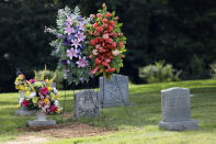 Flowers decorate the Tucker, Miss., grave of Sharon Taylor, mother of Choctaw Central High School's valedictorian Kristina Taylor, and one of several members of the Mississippi Band of Choctaw Indians, who died recently after a bout with coronavirus, Tuesday July 21, 2020. Taylor was buried next to several deceased relatives. As cases of coronavirus rise in the Mississippi, the only federally recognized Native American tribe in the state has seen a devastating impact. (AP Photo/Rogelio V. Solis)