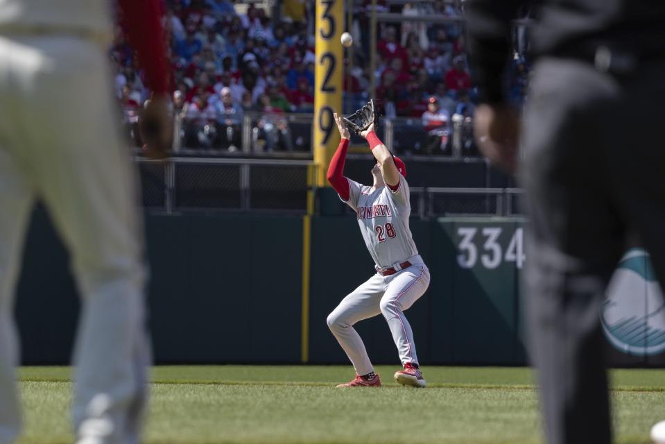 Cincinnati Reds shortstop Kevin Newman (28) catches a fly from Philadelphia Phillies' Kyle Schwarber during the fifth inning of a baseball game, Sunday, April 9, 2023, in Philadelphia. (AP Photo/Laurence Kesterson)