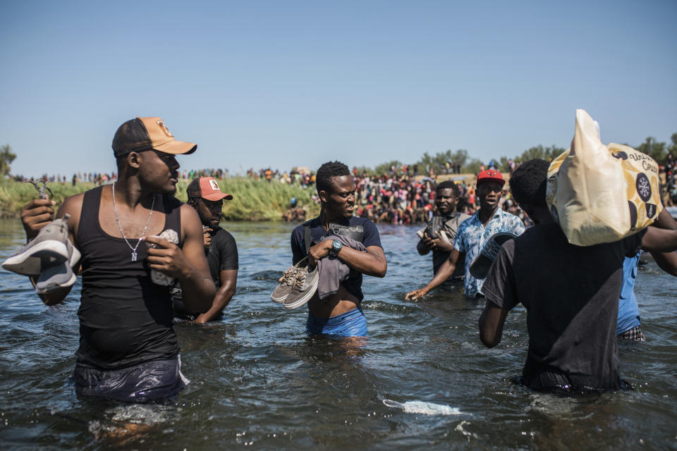 Migrants wade back and forth across the Rio Grande from Ciudad Acuña, Mexico, into Del Rio, Texas, Sunday, Sept. 19, 2021. Thousands of Haitian migrants have been arriving to Del Rio, Texas, as authorities attempt to close the border to stop the flow of migrants. (AP Photo/Felix Marquez)