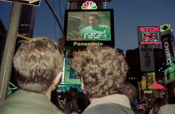 Crowds watching the final episode of the TV series "Seinfeld" broadcast in Times Square in New York City on the Jumbotron screen