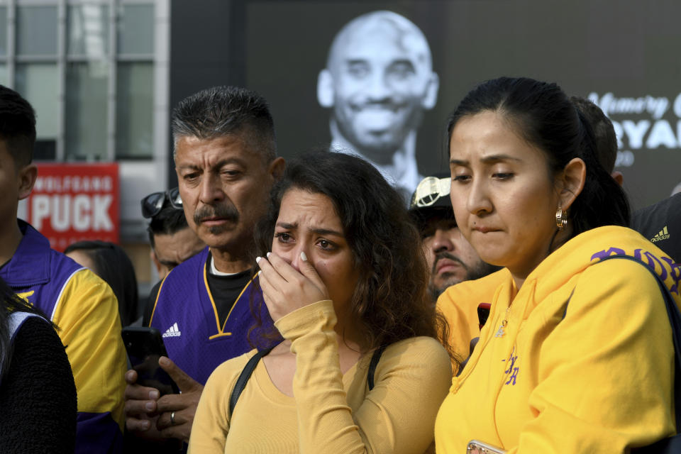 People gather at a memorial for Kobe Bryant near Staples Center Sunday, Jan. 26, 2020, in Los Angeles. Bryant, the 18-time NBA All-Star who won five championships and became one of the greatest basketball players of his generation during a 20-year career with the Los Angeles Lakers, died in a helicopter crash Sunday, Jan. 26, 2020. (AP Photo/Michael Owen Baker)