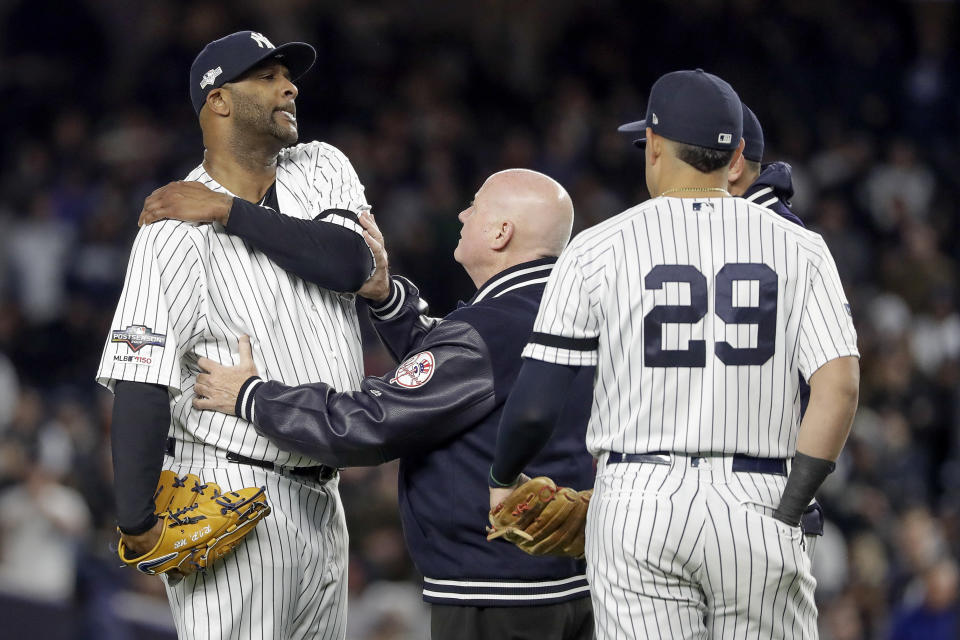 New York Yankees trainer Steve Donohue, center, checks on pitcher CC Sabathia during the eighth inning of Game 4 of baseball's American League Championship Series against the Houston Astros, Thursday, Oct. 17, 2019, in New York. (AP Photo/Frank Franklin II)