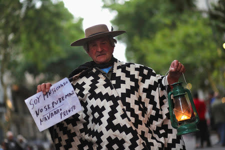 A man wearing traditional Gaucho clothes holds a lantern during a protest against a cost increase in public and utility services in Buenos Aires, Argentina, January 10, 2019. REUTERS/Marcos Brindicci