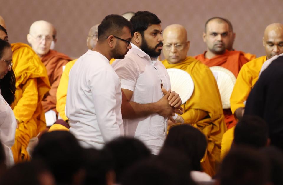 Dhanushka Wickramasinghe, right, father and husband of the victims, takes part in a funeral service for the victims of a mass stabbing that killed a mother, her four young children and a family friend, in Ottawa on Sunday, March 17, 2024.