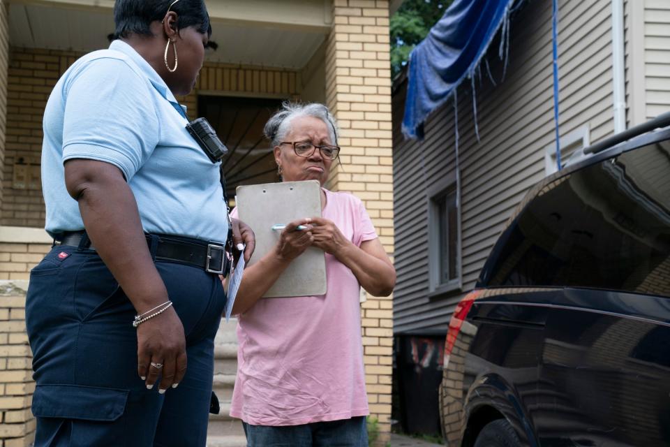 Benta Dixon, city of Detroit Code Enforcement Specialist, left, helps resident Debbie Collins, 69, understand what she can do with two broken-down vehicles in her driveway on Wednesday, July 17, 2024. Dixon helps residents understand that junk cars can not be left abandoned or left unregistered and in disrepair in their driveways and lawns as mentioned in Mayor Mike Duggan's State of the City address, an initiative to help remove said vehicles to help beautify the city.