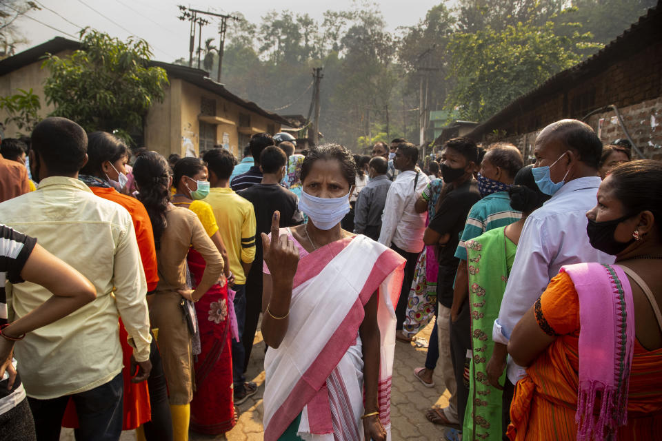 An Assamese voter shows the indelible ink mark on her finger after casting her vote at a polling station during the third phase of assembly election in Gauhati, India, Tuesday, April 6, 2021. Voters in four Indian states and a union territory are casting their ballots, in elections seen as a test for Prime Minister Narendra Modi’s government which is battling the latest surge in coronavirus cases. (AP Photo/Anupam Nath)