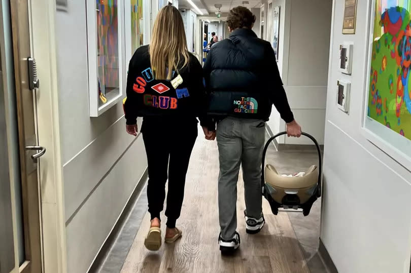 Olly and Amelia shared a snap of them walking down the corridor of the hospital holding hands, with the singer carrying a car seat bearing the newborn