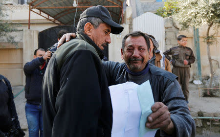 Abu Wissam, whose wife and son were killed by Islamic State, cries as he hugs Lieutenant General Abdelwahab al-Saadi as he holds up the militants' execution order for his son, east of Mosul, Iraq, January 11, 2017. Pictures January 11, 2017. REUTERS/Ahmed Saad