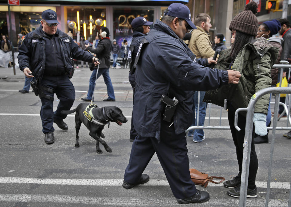 FILE - In this Dec. 31, 2015, file photo, pedestrians submit to a search as they enter Times Square in New York for the New Year's Even celebration. Although New York City police have turned to familiar tactics ahead of the iconic Thursday, Dec. 31, 2020, ball drop, the department's playbook this year includes an unusual mandate: preventing crowds from gathering in Times Square. (AP Photo/Seth Wenig, File)