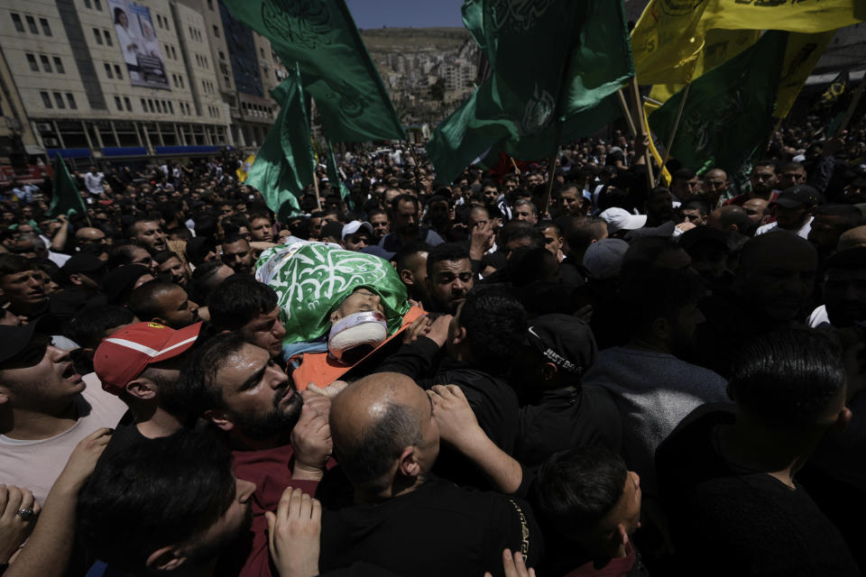 Palestinians carry the body of Hassan Qatnani,, draped in the Hamas militant group flag, during his funeral in the West Bank city of Nablus, Thursday, May 4, 2023. The Israeli military says it has killed Qatnani, Moaz al-Masri and Ibrahim Jabr for being behind an attack last month on a car near a Jewish West Bank settlement that killed a British-Israeli mother and two of her daughters. Hamas said the men were its members and claimed responsibility for the attack (AP Photo/Majdi Mohammed)