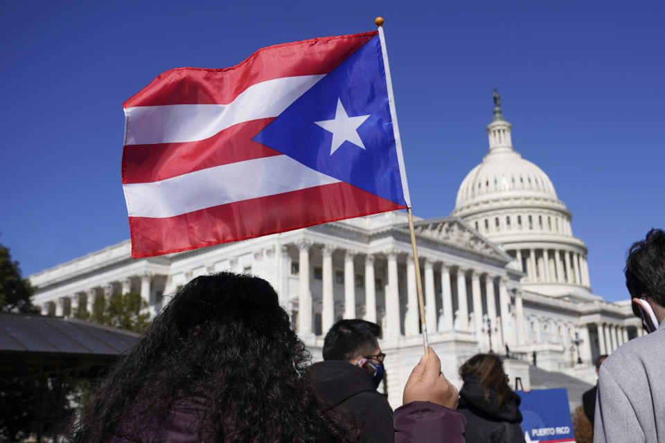 A woman waves the flag of Puerto Rico during a news conference on Puerto Rican statehood on Capitol Hill on March 2, 2021.  (Patrick Semansky / AP file)