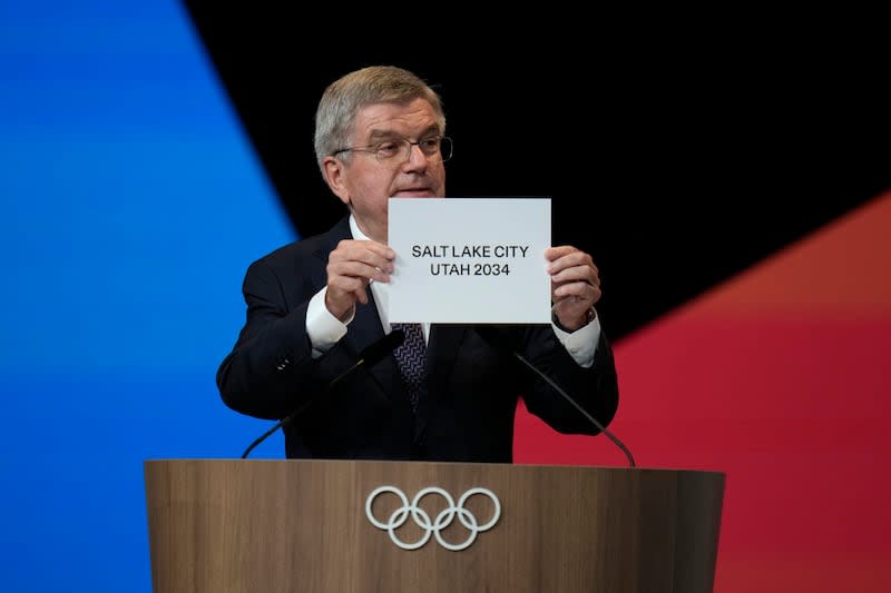 IOC president Thomas Bach holds the board Salt Lake City during the 142nd IOC session at the 2024 Summer Olympics, Wednesday, July 24, 2024, in Paris, France. Salt Lake City was confirmed as host for the 2034 Winter Games by International Olympic Committee. | Natacha Pisarenko