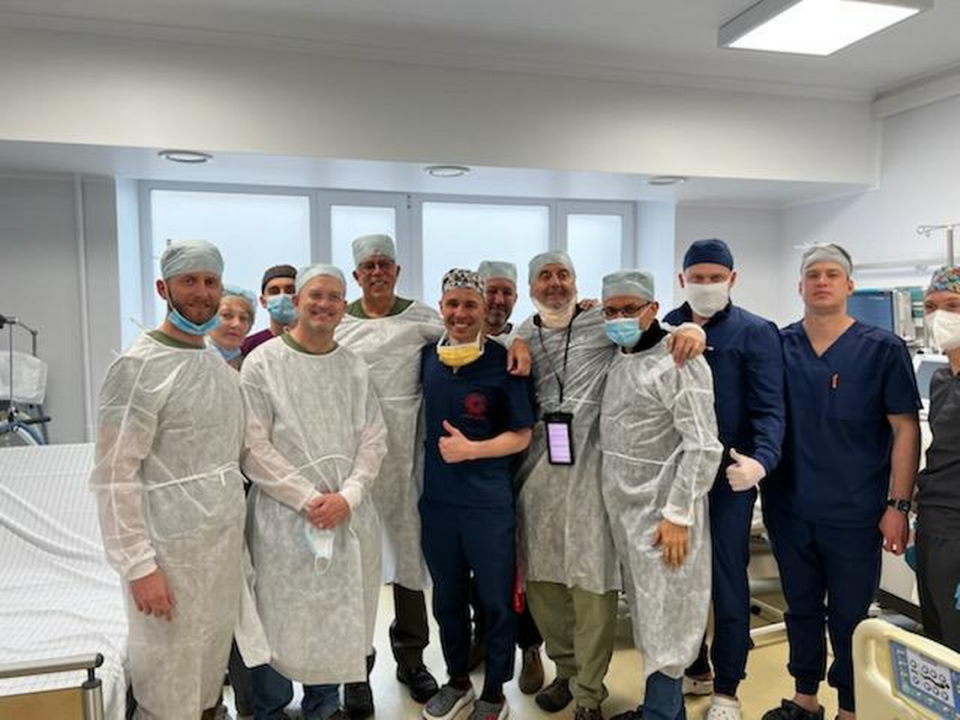 El Dr. Enrique Ginzburg, director médico de traumatología y jefe de cirugía del Centro de Traumatología Ryder del Jackson Health System, con un grupo de médicos y proveedores de atención sanitaria en el Hospital Clínico de Urgencias de Lviv, en Ucrania, en abril.