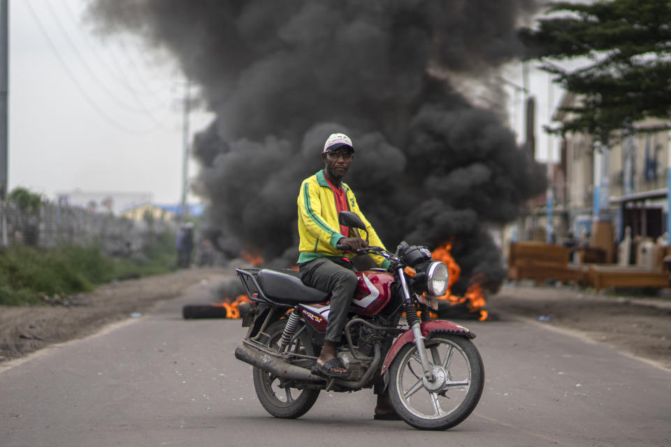 A man watches as security forces clash with supporters of presidential candidate Martin Fayulu outside his party's headquarters, in Kinshasa, Democratic Republic of the Congo, Wednesday, Dec. 27, 2023. Fayulu, a main opposition candidate accused police of using live bullets to break up a protest Wednesday in Congo's capital, as demonstrators demanded a re-do for last week's presidential election. Fayulu is one of five opposition candidates who say the election should be rerun and question its credibility. Some rights groups and international observers also have questioned the vote. (AP Photo/Mosa'ab Elshamy)