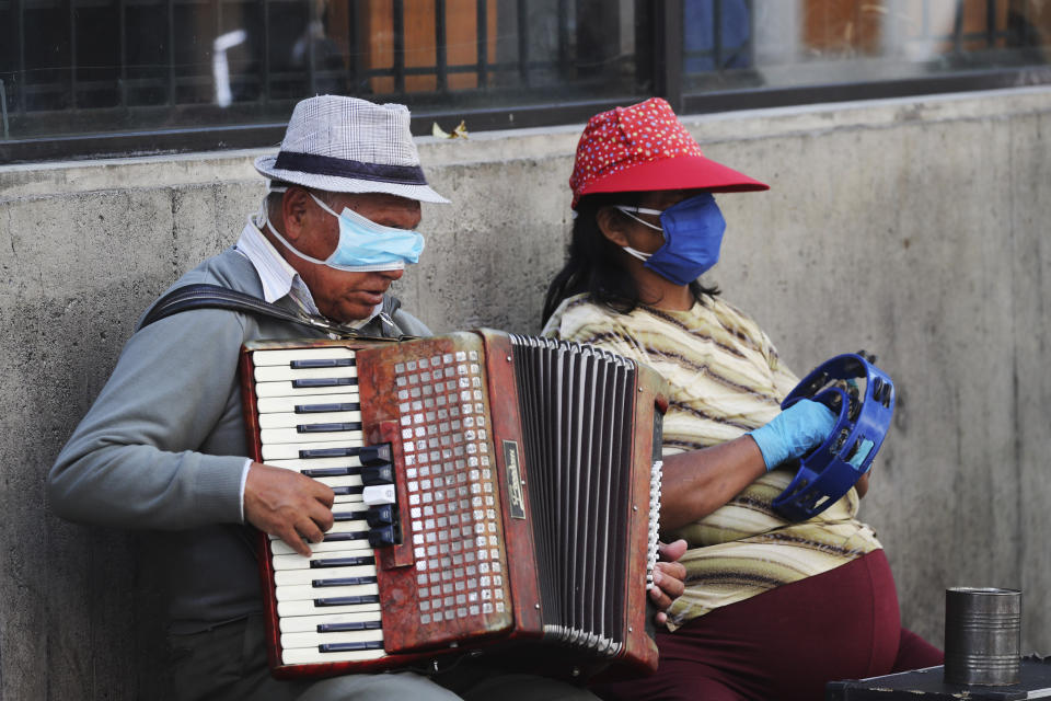 A blind man and his musical partner play for tips in downtown Quito, Ecuador, April 3, 2020. (AP Photo/Dolores Ochoa)