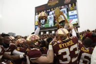 Minnesota football players hold up the Governor's Victory Bell after winning 31-26 against Penn State during an NCAA college football game Saturday, Nov. 9, 2019, in Minneapolis. (AP Photo/Stacy Bengs)
