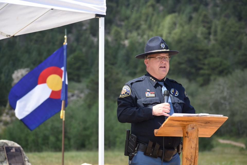 Larimer County Sheriff Justin Smith speaks to the crowd  during the dedication of the Fallen Aviator Firefighter Memorial at Hermit Park Open Space near Estes Park, Colo., on Wednesday, Aug. 17, 2022.