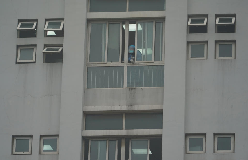 A hospital staff member looks out a window of the Wuhan Medical Treatment Center, where some infected with a new virus are being treated, in Wuhan, China, Wednesday, Jan. 22, 2020. The number of cases of a new coronavirus from Wuhan has risen to over 400 in China health authorities said Wednesday. (AP Photo/Dake Kang)