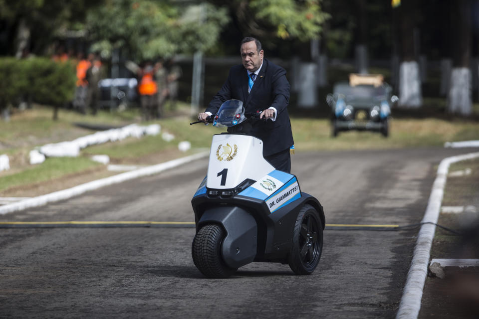 Guatemala's newly sworn-in President Alejandro Giammattei drives a vehicle as he arrives for a ceremony to recognize him as commander and chief of the military at the Mariscal Zabala military base in Guatemala City, Wednesday, Jan. 15, 2020, one day after his inauguration. (AP Photo/Oliver de Ros)