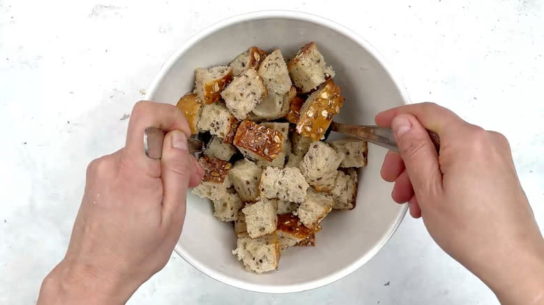 tossing bread cubes in oil