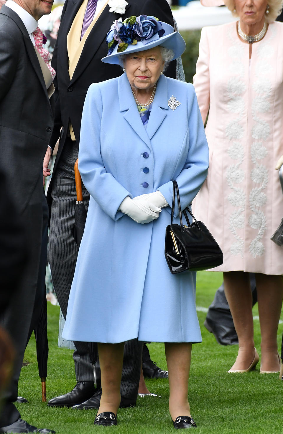 The Queen wore a cornflower blue coat and floral hat, believed to be by Angela Kelly, for day one of Royal Ascot. <em>[Photo: PA]</em>