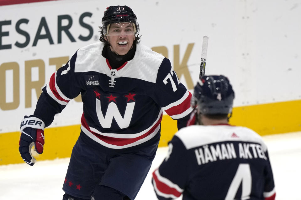 Washington Capitals right wing T.J. Oshie, left, celebrates with teammate defenseman Hardy Haman Aktell, right, while wearing a neck guard after a goal that was later disallowed in the third period of an NHL hockey game against the New York Islanders, Thursday, Nov. 2, 2023, in Washington. (AP Photo/Mark Schiefelbein)