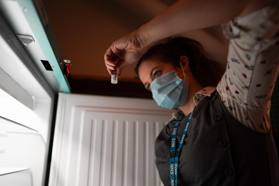 Pharmacist Ciara Duffy removes Pfizer BioNTech Covid-19 vaccines from a fridge (PA Wire)