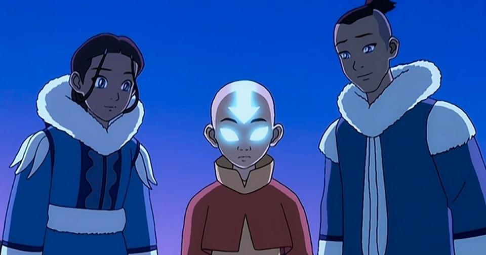 Two boys and a girl look down at something off screen while one of the boys' eyes glow