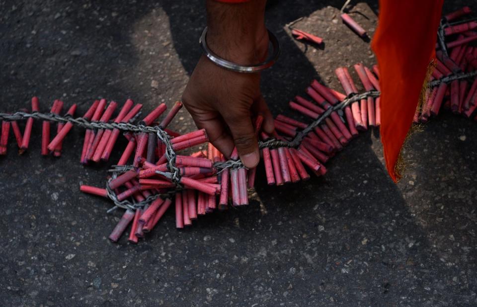 File: A person seeing arranging garlands of firecrackers made up small bombs in New Delhi (AFP via Getty Images)