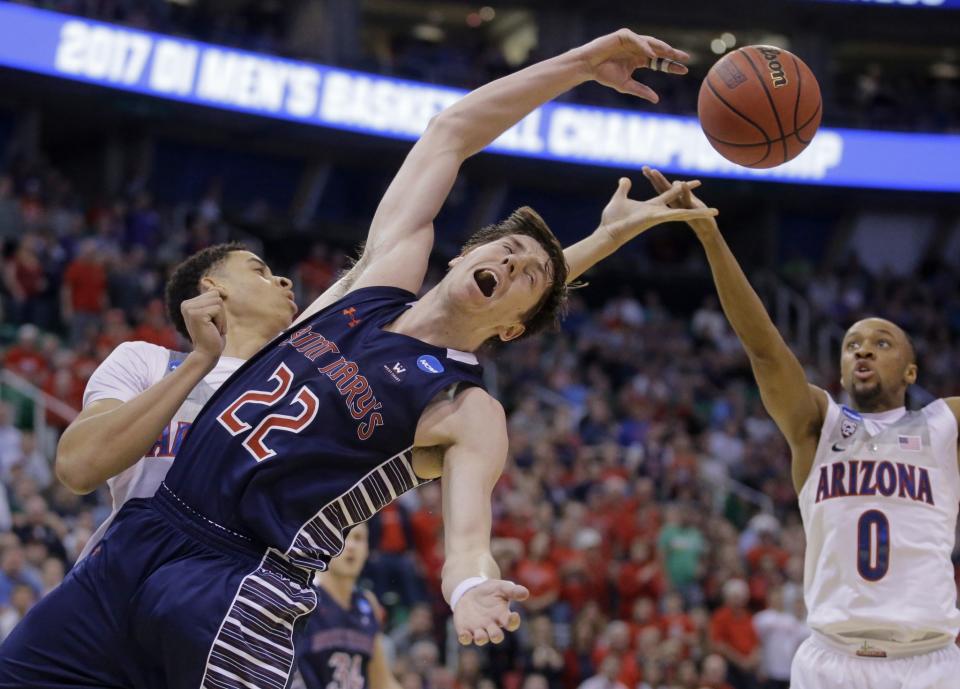 <p>Saint Mary’s forward Dane Pineau (22) reaches for the ball as Arizona’s Chance Comanche, rear, and Parker Jackson-Cartwright (0) defend during the second half of a second-round college basketball game in the men’s NCAA Tournament Saturday, March 18, 2017, in Salt Lake City. Arizona won 69-60. (AP Photo/Rick Bowmer) </p>