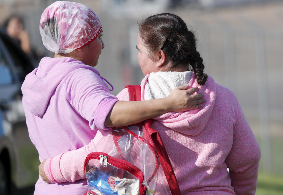 Friends and family console each other while U.S. immigration officials raided Koch Foods Inc., plant in Morton, Miss., Wednesday, Aug. 7, 2019. U.S. immigration officials raided several Mississippi food processing plants on Wednesday and signaled that the early-morning strikes were part of a large-scale operation targeting owners as well as employees. (AP Photo/Rogelio V. Solis)