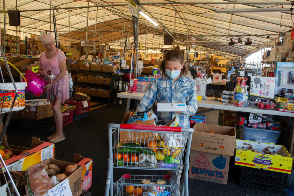 Paula and Max shop at a seasonal market for dented cans and near-expired foods at the Quartzsite Grocery and Drug Store on Feb. 8. The market caters to the mobile living community, which swells during the winter time with people seeking the warm weather.<span class="copyright">Nina Riggio for TIME</span>