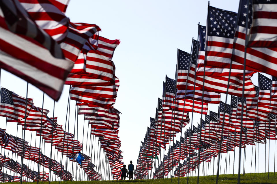 <p>Bianca Burton, center left, and Erin Schultheis walk around the Pepperdine University’s annual display of flags honoring the victims of the 9/11 terrorist attacks, Monday, Sept. 10, 2018, in Malibu, Calif. (Photo: Jae C. Hong/AP) </p>