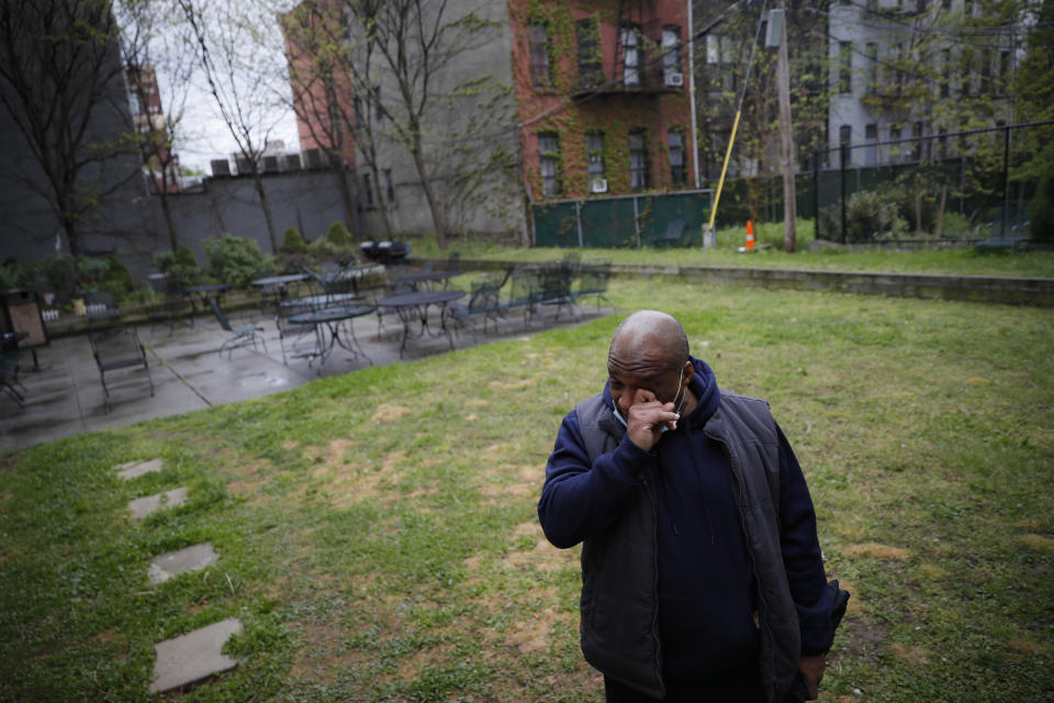 Milton I., 50, a resident living with schizophrenia at The Robert Meineker House, wipes his eyes as he speaks about the loneliness caused by social distancing in an empty common area, Wednesday, May 6, 2020, in the Brooklyn borough of New York. Even before the pandemic, access to mental health services in the U.S. could be difficult, including for people with insurance. Now experts fear COVID-19 will make the situation worse. (AP Photo/John Minchillo)