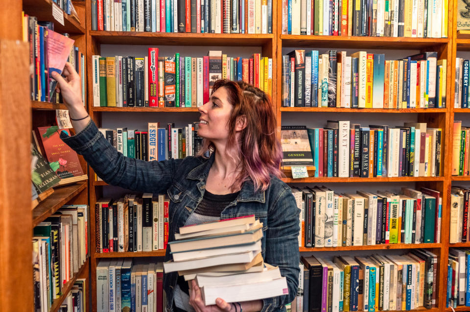 A person putting books on a shelf