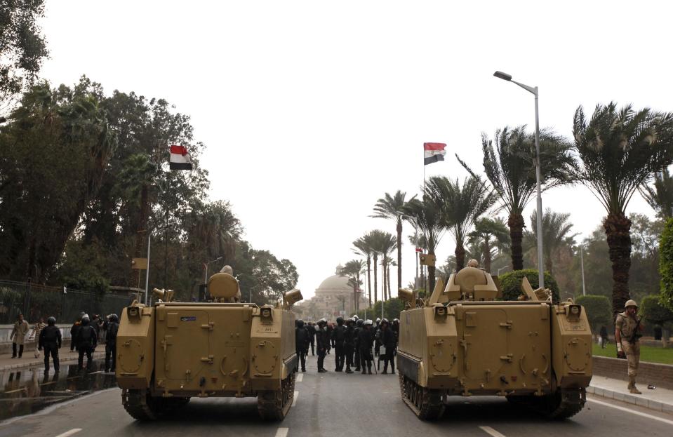 Army vehicles are parked outside Cairo university during clashes between riot policemen and Cairo University students, who are supporters of the Muslim Brotherhood and ousted Egyptian President Mohamed Mursi, in Cairo December 11, 2013. (REUTERS/Mohamed Abd El Ghany)