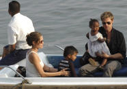 Hollywood star Brad Pitt (R) carries adopted daughter Zahara while Angelina Jolie (2nd L) sits with adopted son Maddox during a boat ride in Mumbai November 18, 2006. REUTERS/Stringer (INDIA)