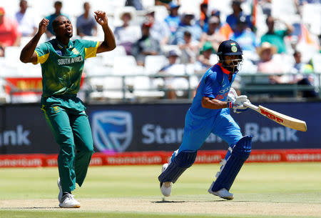 Cricket - India v South Africa - Third One Day International - Newlands Stadium, Cape Town, South Africa - February 7, 2018. India's Virat Kohli runs past South Africa's Andile Phehlukwayo. REUTERS/Mike Hutchings