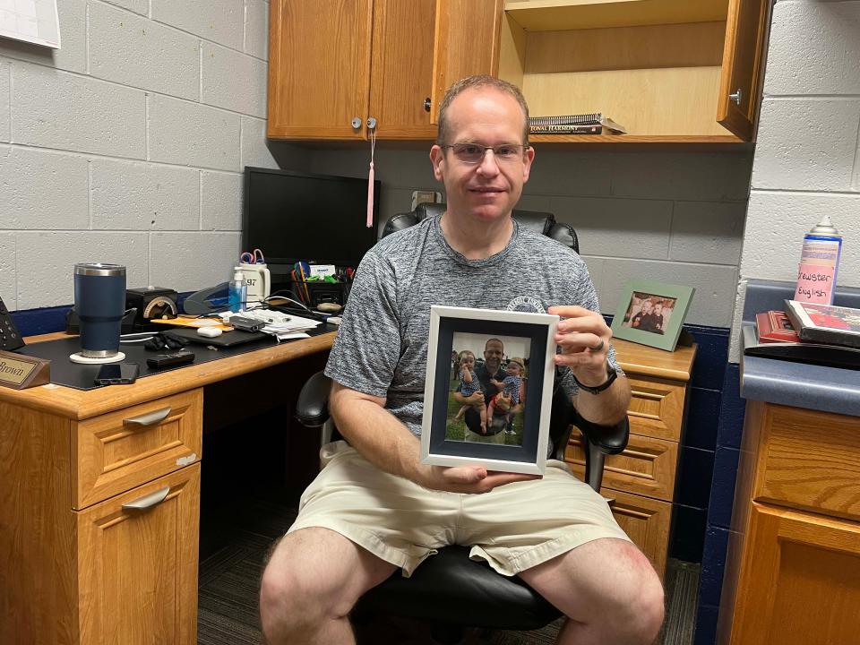Rodney Brown moves into his new office as assistant band director, placing a photo of himself with his twin daughters front and center on his desk at Farragut High School Tuesday, July 12, 2022.