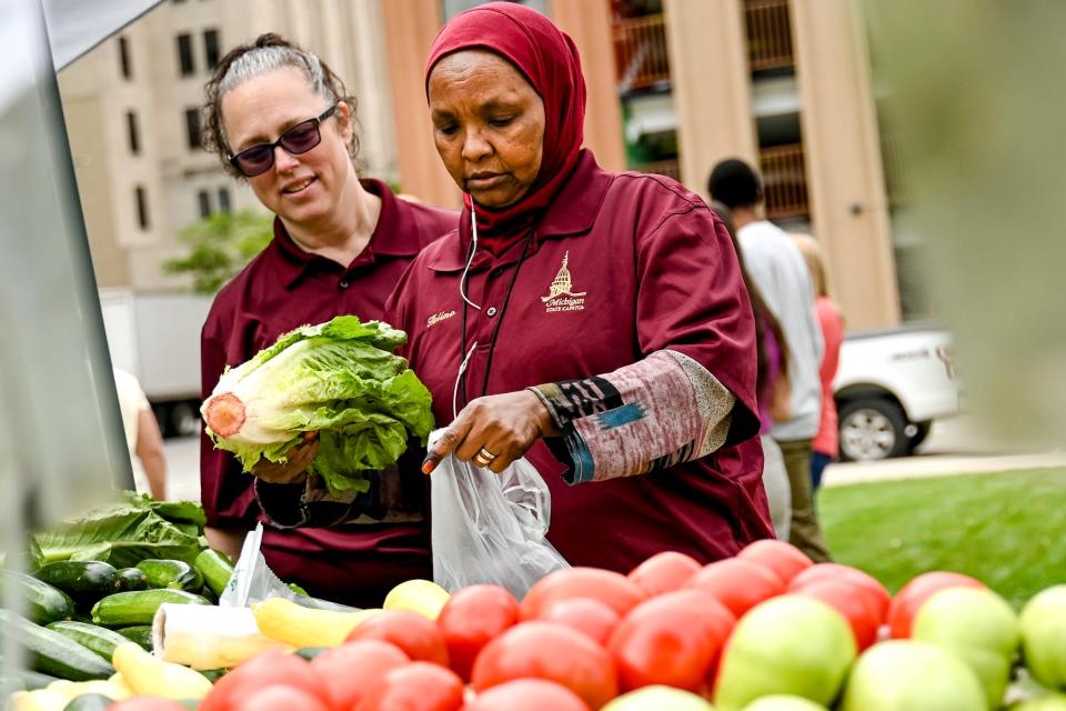Halimo Omar, right, and Jeanette Dubendorf shop for produce on Tuesday, July 18, 2023, at Farmers Market at the Capitol in downtown Lansing.
