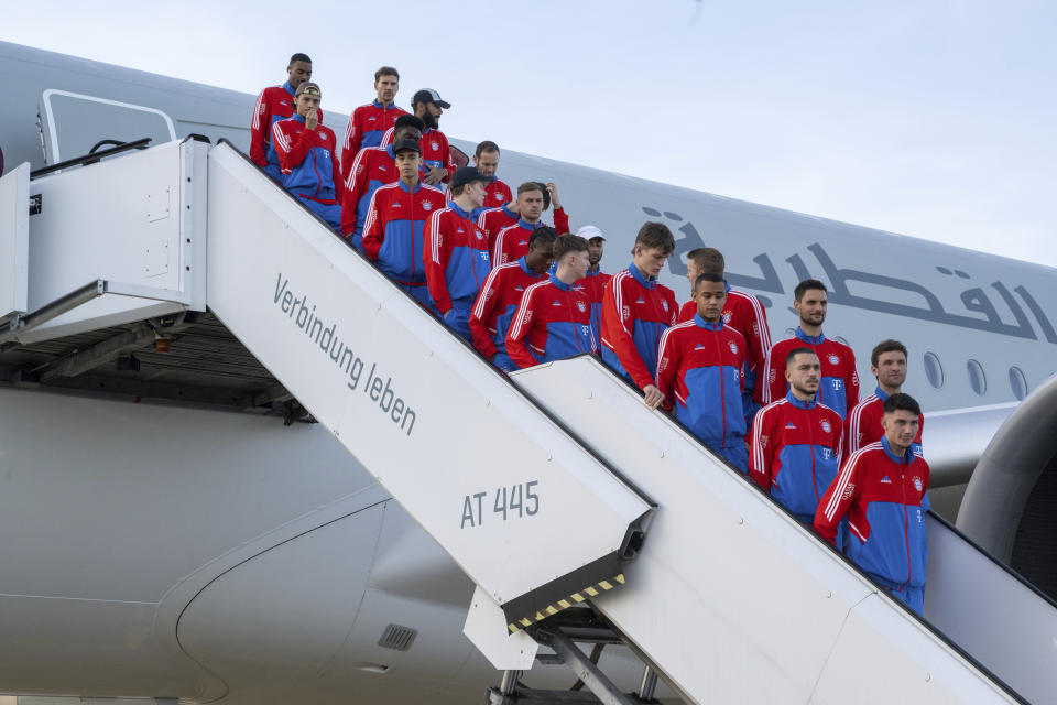 The players of the German Bundesliga team FC Bayern Munich stand on a staircase of an airplane of the airline Qatar Airways at the airport in Munich, Germany, Friday, Jan. 6, 2023. The Bayern Munich team flies to Qatar on Friday for its winter training camp amid uncertainty over the club’s contentious sponsorship agreement with the Persian Gulf country. (Peter Kneffel/dpa via AP)