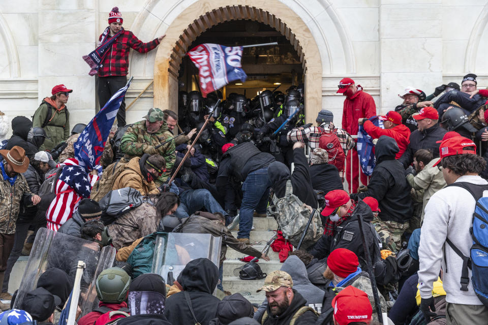 Rioters clash with police at an entrance to the Capitol.