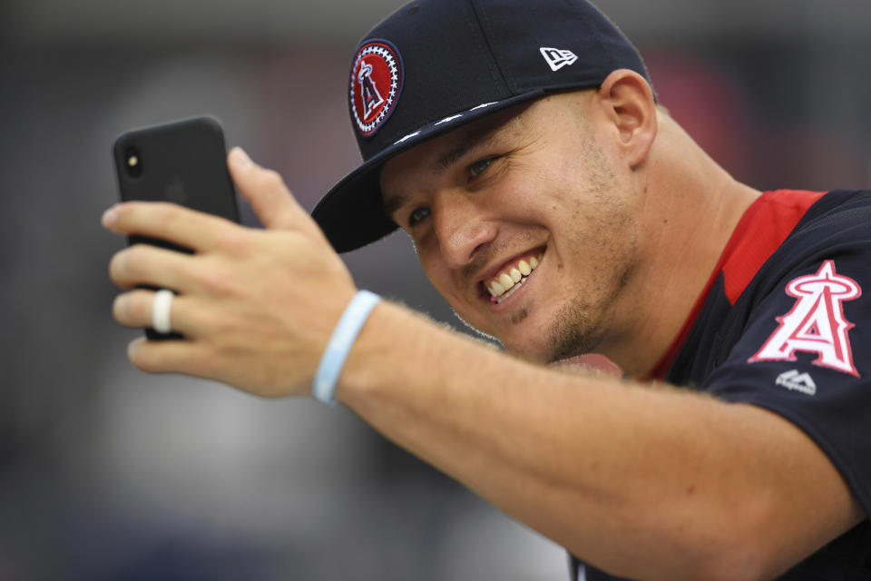 FILE - In this July 16, 2018, file photo, American League All-Star Mike Trout, of the Los Angeles Angels, takes a photo on the field ahead of the All-Star Home Run Derby at Nationals Park in Washington. A person familiar with the negotiations tells The Associated Press Tuesday, March 19, 2019, that Trout and the Angels are close to finalizing a record $432 million, 12-year contract that would shatter the record for the largest deal in North American sports history. (AP Photo/Patrick Semansky)