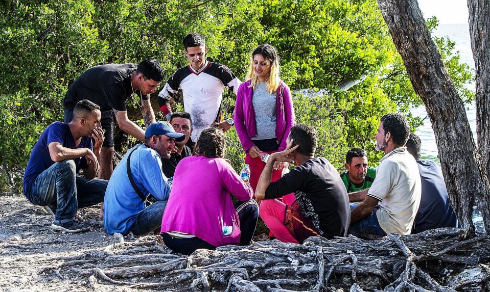 Un grupo de migrantes cubanos se reúne cerca de un camino en la isla Duck Key el lunes 2 de enero de 2023, en los Cayos de Florida. (Pedro Portal/Miami Herald vía AP)