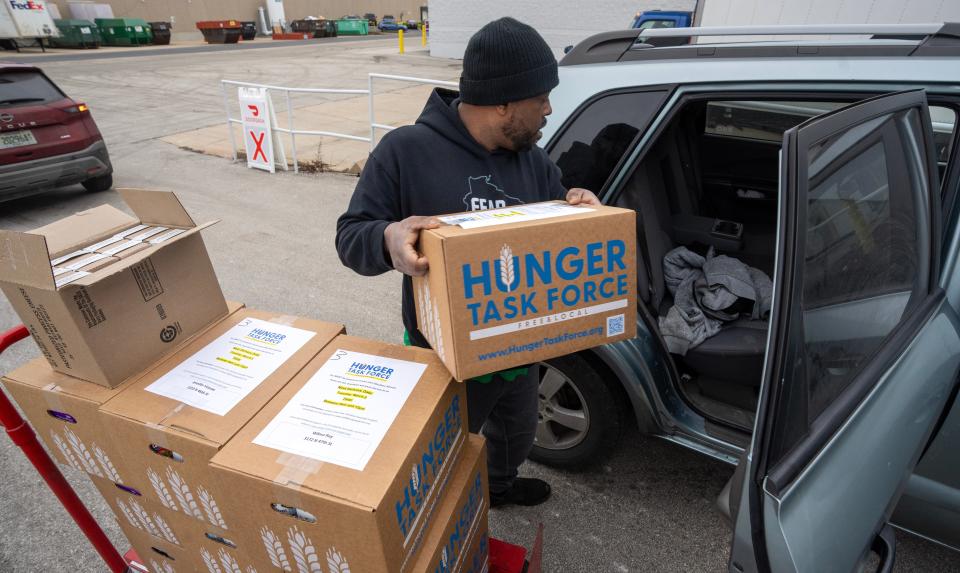 DoorDash driver Ryan Leech loads his car with food to be delivered at Hunger Task Force in West Milwaukee.