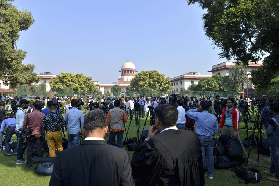 FILE- A crowd gathers anticipating ruling on a disputed temple-mosque land in the northern Indian town of Ayodhya outside the Supreme Court in New Delhi, India, Nov. 9, 2019. Muslim groups for decades waged a court fight for the restoration of Babri mosque that wad demolished by Hindu mobs in December 1992, sparking nationwide riots that killed more than 2,000 people, mostly Muslims. The dispute ended in 2019 when, the court granted the site to Hindus and gave a different plot of land in an isolated area to Muslims for a mosque. (AP Photo, File)