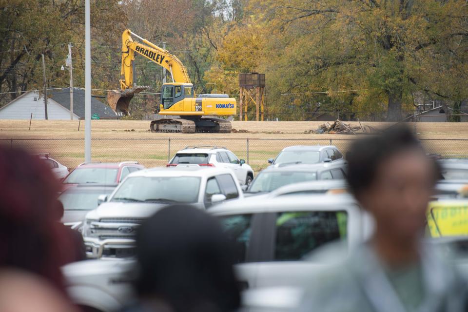 Machinery starts breaking up ground as attendees chat during the Hub City Central Stadium groundbreaking near Oman Arena, Jackson, Tenn., on Wednesday, Nov. 15, 2023.
